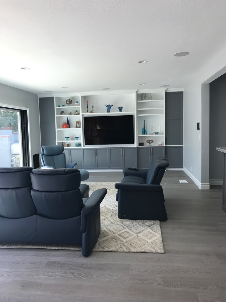 Large transitional open concept medium tone wood floor and gray floor family room photo in Los Angeles with gray walls and a media wall
