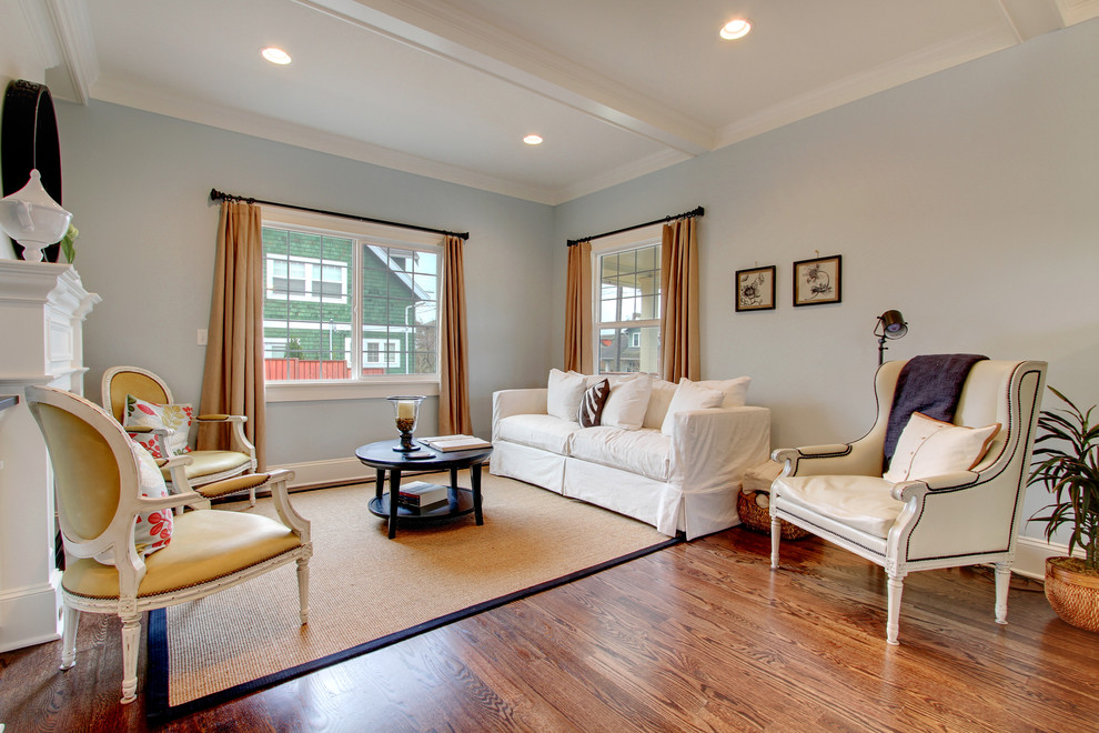 Cette photo montre une salle de séjour nature avec un mur gris, un sol en bois brun et une cheminée standard.