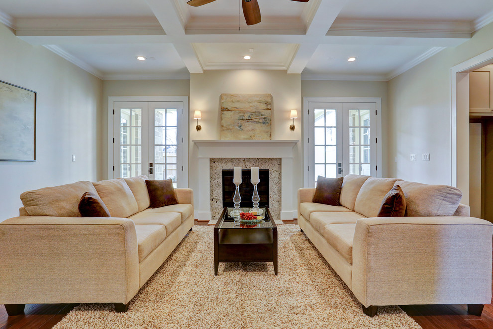 Example of a large arts and crafts open concept medium tone wood floor family room design in Houston with beige walls, a standard fireplace, a stone fireplace and a wall-mounted tv