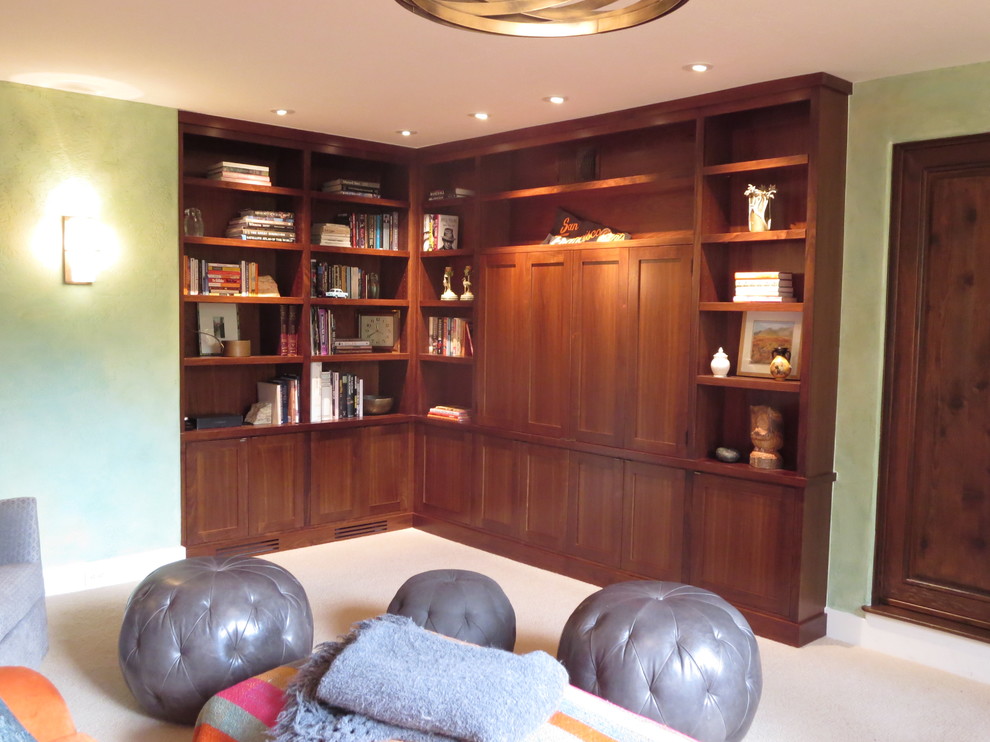 Стильный дизайн: открытая гостиная комната среднего размера в стиле фьюжн с с книжными шкафами и полками, зелеными стенами, ковровым покрытием и скрытым телевизором - последний тренд
