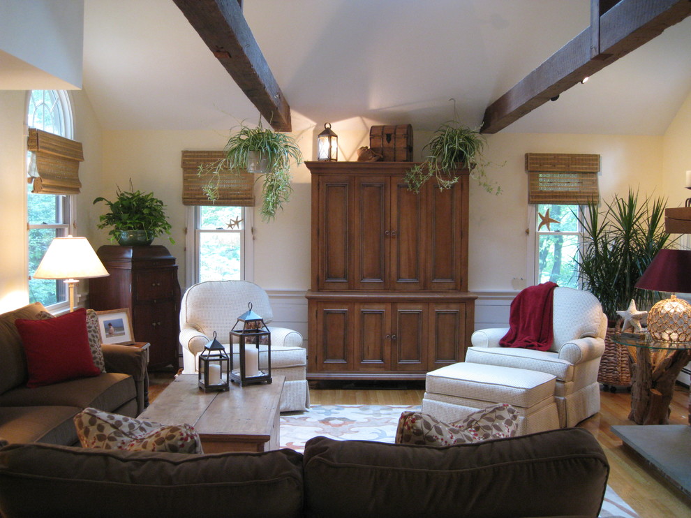 Example of a large classic open concept light wood floor and brown floor family room design in Providence with yellow walls, no fireplace, a brick fireplace and a media wall