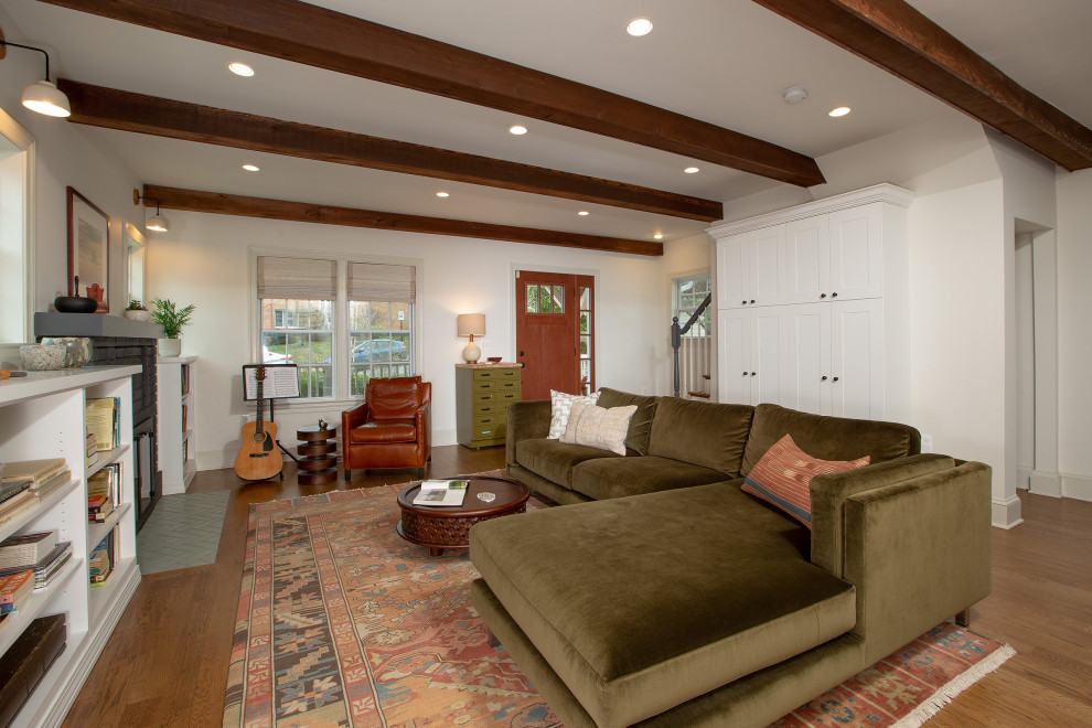 Imagen de sala de estar abierta ecléctica de tamaño medio con paredes beige, suelo de madera en tonos medios, todas las chimeneas, televisor colgado en la pared y suelo marrón