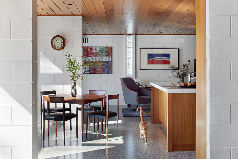 Modelo de sala de estar abierta vintage de tamaño medio con paredes blancas, suelo de cemento y suelo gris