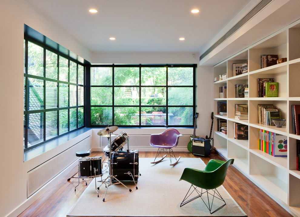 На фото: гостиная комната в стиле модернизм с музыкальной комнатой и ковром на полу