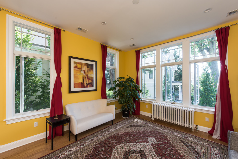 Idee per un soggiorno bohémian di medie dimensioni e aperto con libreria, pareti gialle, pavimento in legno massello medio e pavimento beige