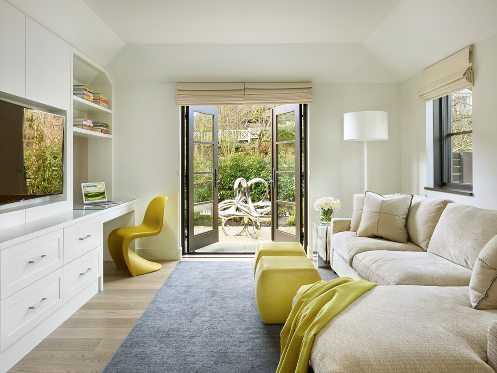 Diseño de sala de estar clásica renovada con paredes blancas, suelo de madera clara y pared multimedia