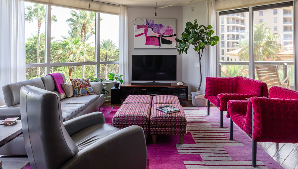 Cette image montre une grande salle de séjour design ouverte avec un téléviseur indépendant, un mur gris, parquet foncé et un sol marron.