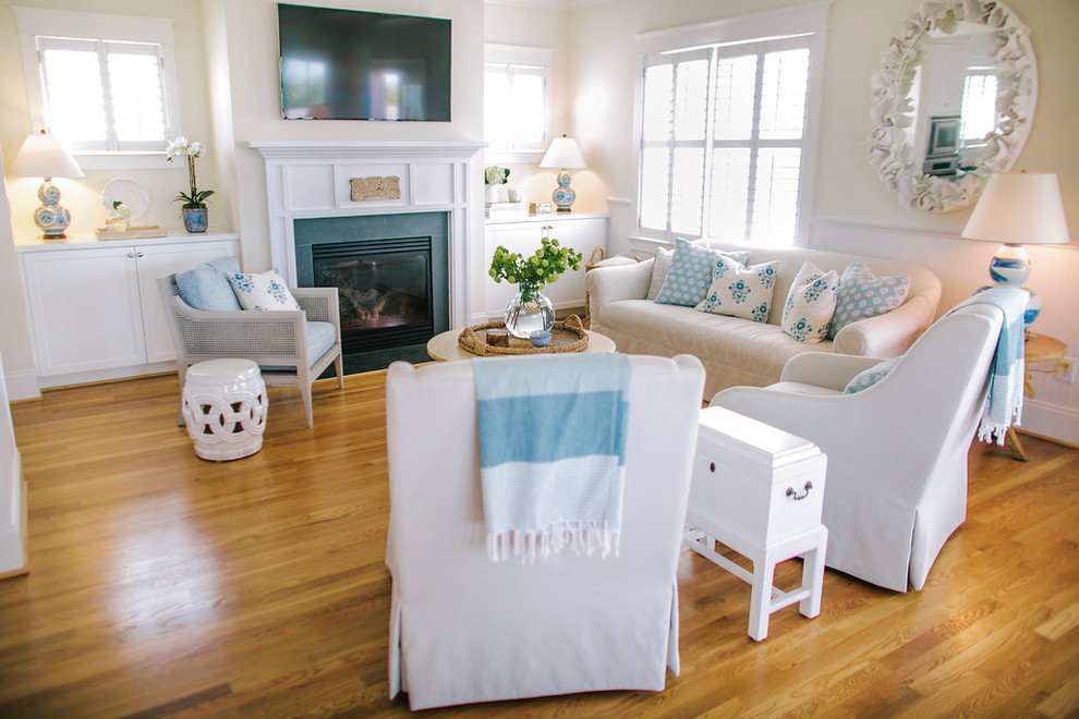 Family room - mid-sized coastal open concept medium tone wood floor family room idea in Houston with yellow walls, a standard fireplace, a tile fireplace and a wall-mounted tv