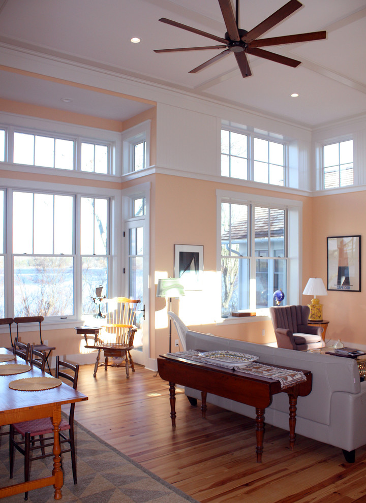 Esempio di un soggiorno tradizionale di medie dimensioni e aperto con pareti arancioni e parquet chiaro