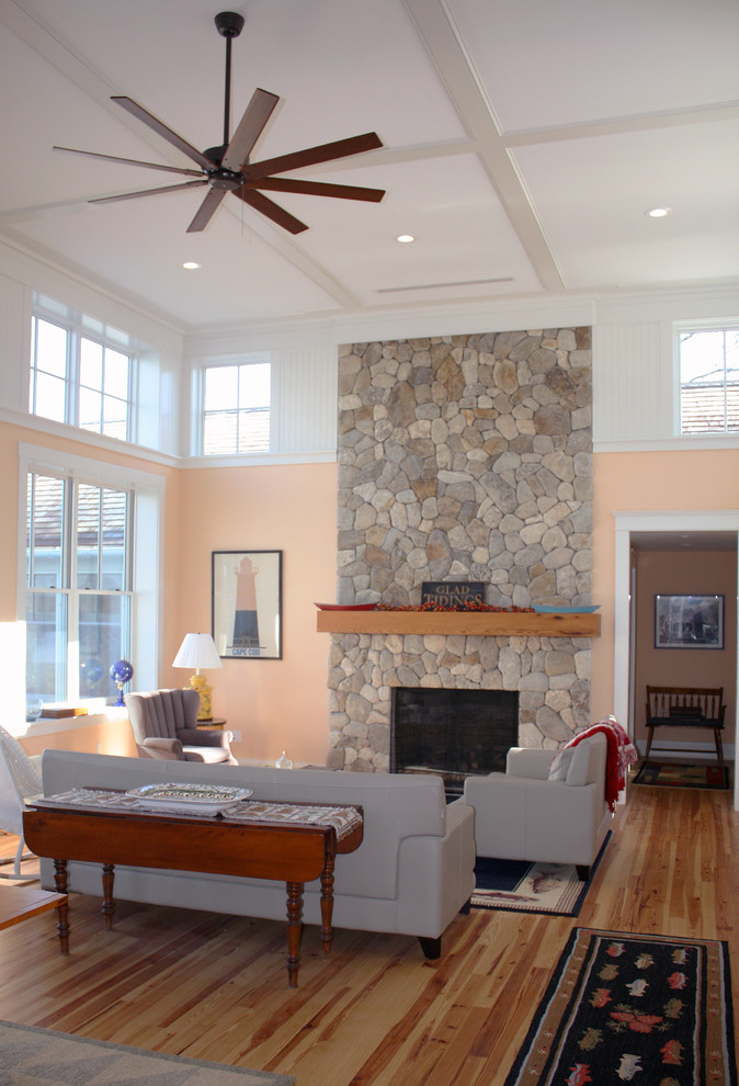 Cette image montre une salle de séjour traditionnelle de taille moyenne et ouverte avec parquet clair, une cheminée standard et un manteau de cheminée en pierre.