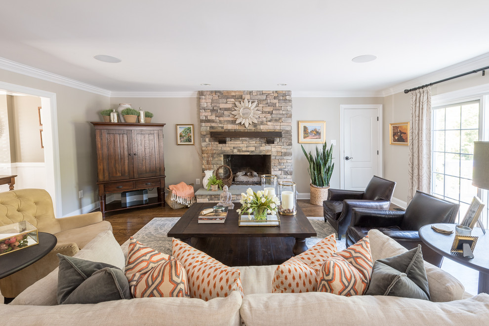 Example of a large transitional dark wood floor living room design in DC Metro with a standard fireplace, a stone fireplace, beige walls and a concealed tv