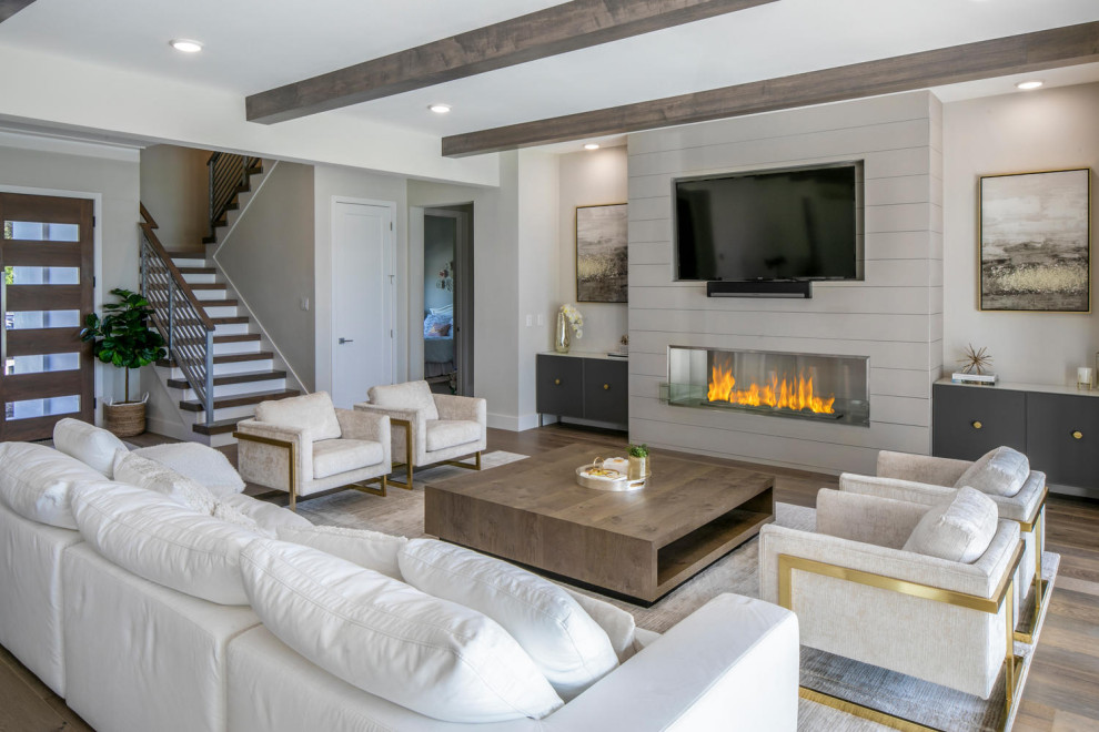 Family room - huge modern open concept medium tone wood floor, brown floor and exposed beam family room idea in Tampa with white walls, a wall-mounted tv and a shiplap fireplace