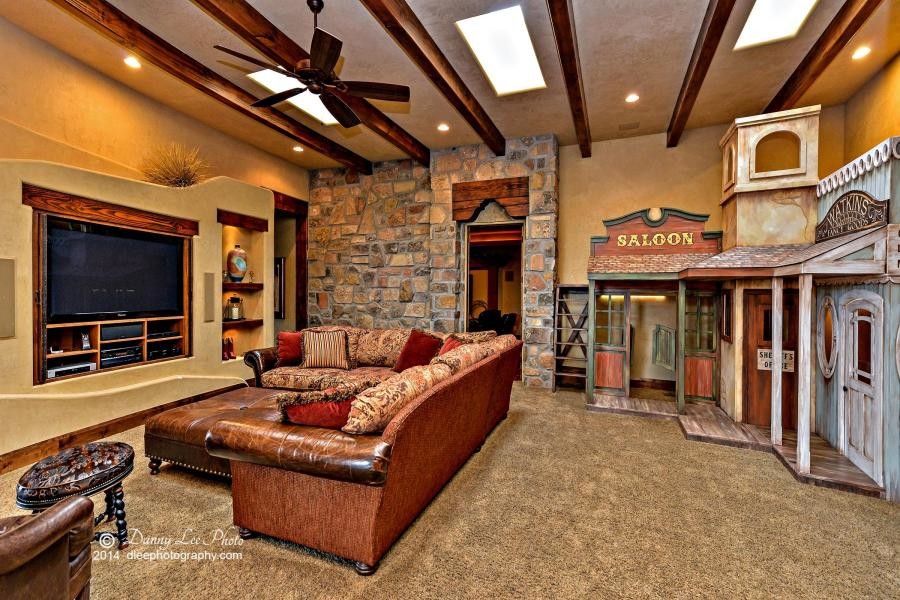 Family room - mid-sized southwestern open concept carpeted family room idea in Salt Lake City with beige walls, a standard fireplace, a stone fireplace and a media wall