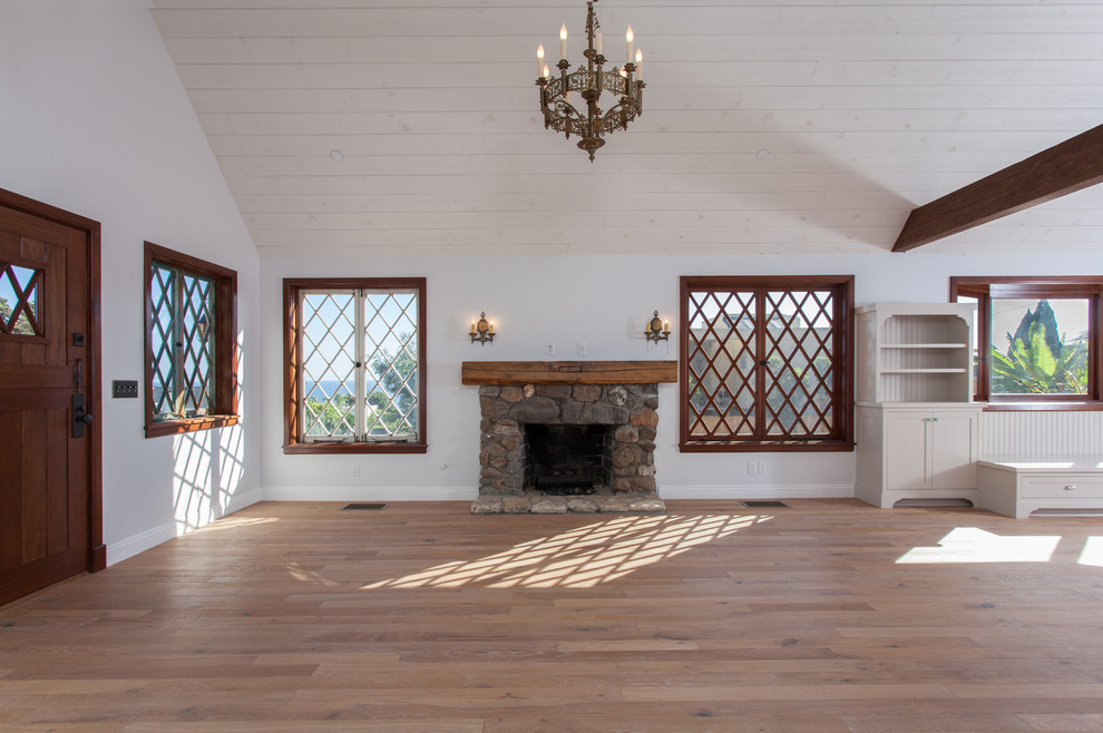 Inspiration for a large craftsman open concept medium tone wood floor family room remodel in Orange County with a stone fireplace, white walls and a standard fireplace