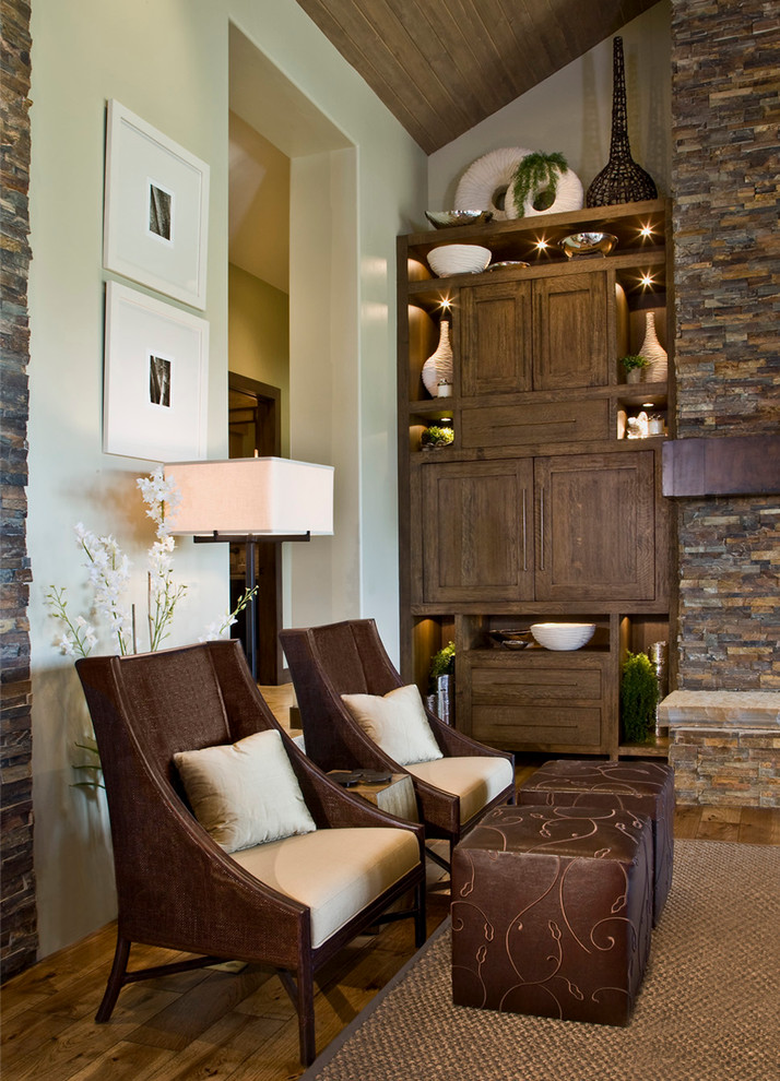 Foto de sala de estar cerrada rural grande con paredes beige, suelo de madera en tonos medios, todas las chimeneas, marco de chimenea de piedra y pared multimedia