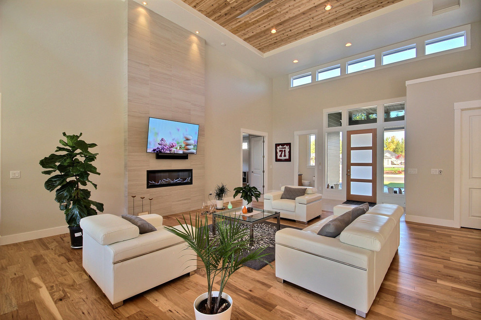 Exempel på ett mycket stort modernt allrum med öppen planlösning, med beige väggar, mellanmörkt trägolv, en bred öppen spis, en spiselkrans i trä, en väggmonterad TV och brunt golv