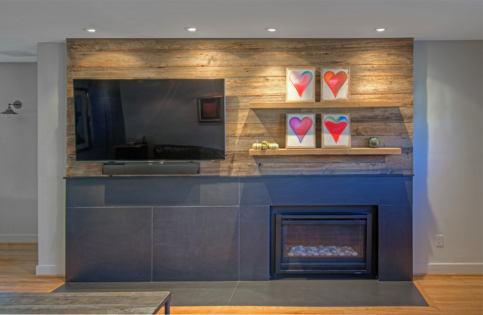 Photo of a small contemporary open plan games room in DC Metro with grey walls, light hardwood flooring, a standard fireplace, a stone fireplace surround and a wall mounted tv.