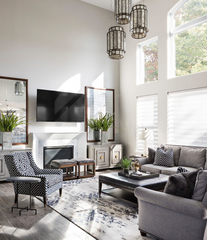 Foto de sala de estar abierta clásica renovada con paredes blancas, todas las chimeneas, marco de chimenea de piedra, televisor colgado en la pared, suelo gris y alfombra