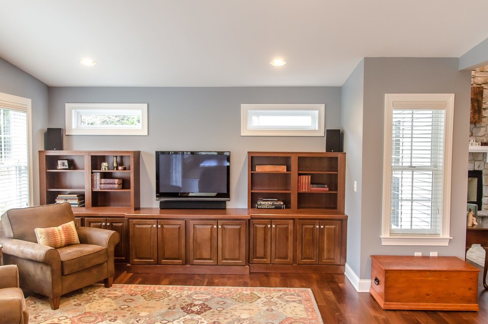 This is an example of a large classic enclosed games room in Other with a reading nook, grey walls, medium hardwood flooring, a freestanding tv and multi-coloured floors.