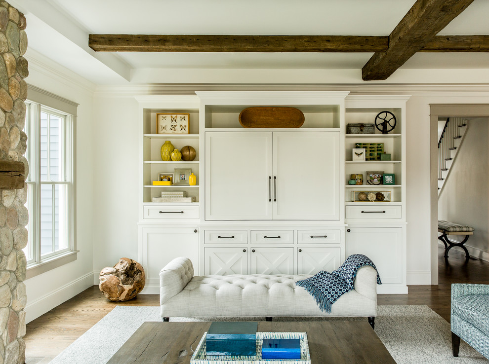 Imagen de sala de estar abierta de estilo de casa de campo con paredes blancas, suelo de madera oscura, todas las chimeneas, marco de chimenea de piedra y pared multimedia