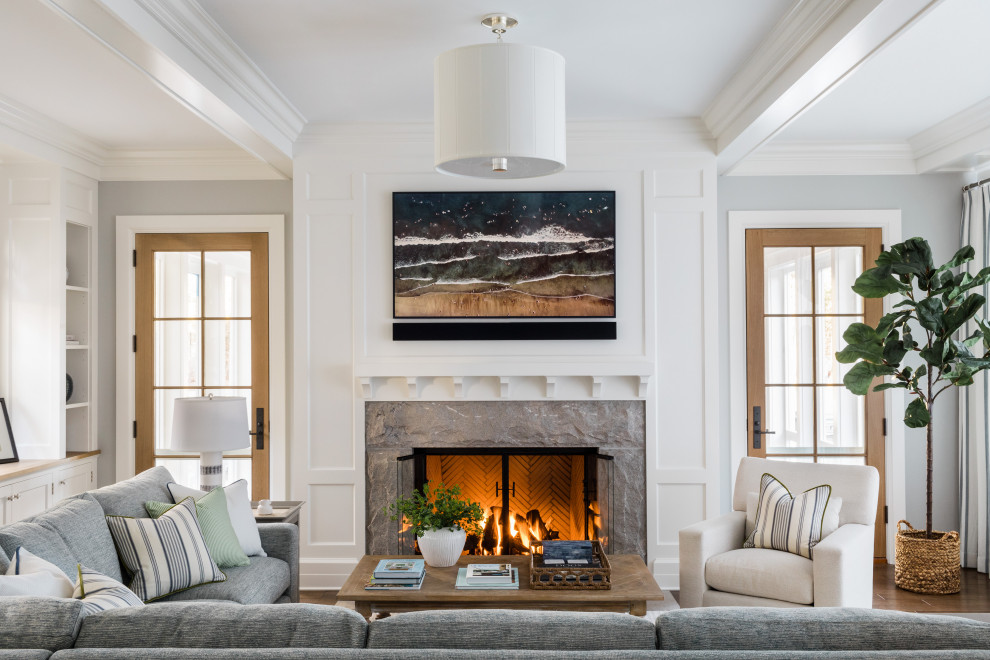 Inspiration for a large transitional enclosed medium tone wood floor and brown floor family room remodel in Boston with gray walls, a standard fireplace, a tile fireplace and a wall-mounted tv