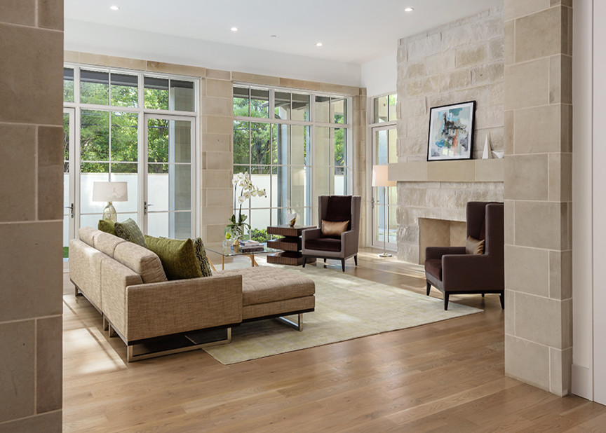 Diseño de sala de estar abierta tradicional renovada grande con paredes blancas, suelo de madera clara, todas las chimeneas, marco de chimenea de piedra y televisor colgado en la pared