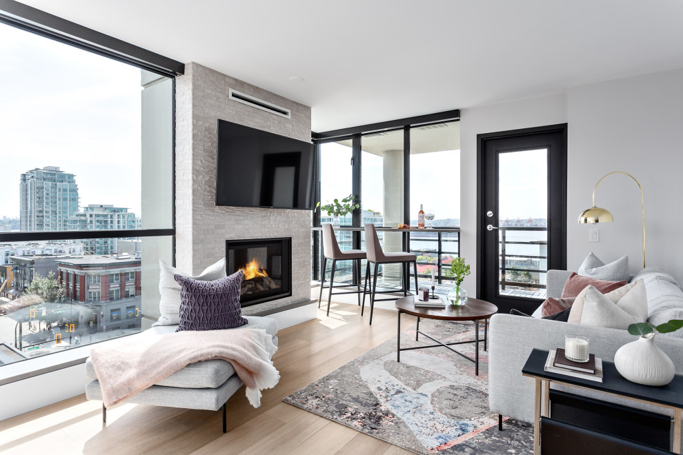 Modernes Wohnzimmer mit weißer Wandfarbe, Kamin, TV-Wand und braunem Boden in Vancouver