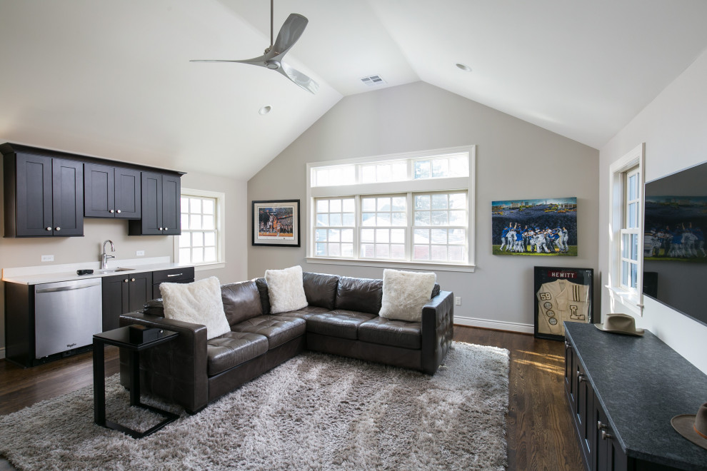 Immagine di un grande soggiorno tradizionale chiuso con sala giochi, pareti grigie, pavimento in legno massello medio, TV a parete e soffitto a volta