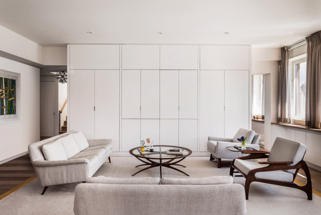 Aménagement d'une salle de séjour rétro de taille moyenne et ouverte avec un téléviseur dissimulé, un mur blanc et parquet clair.