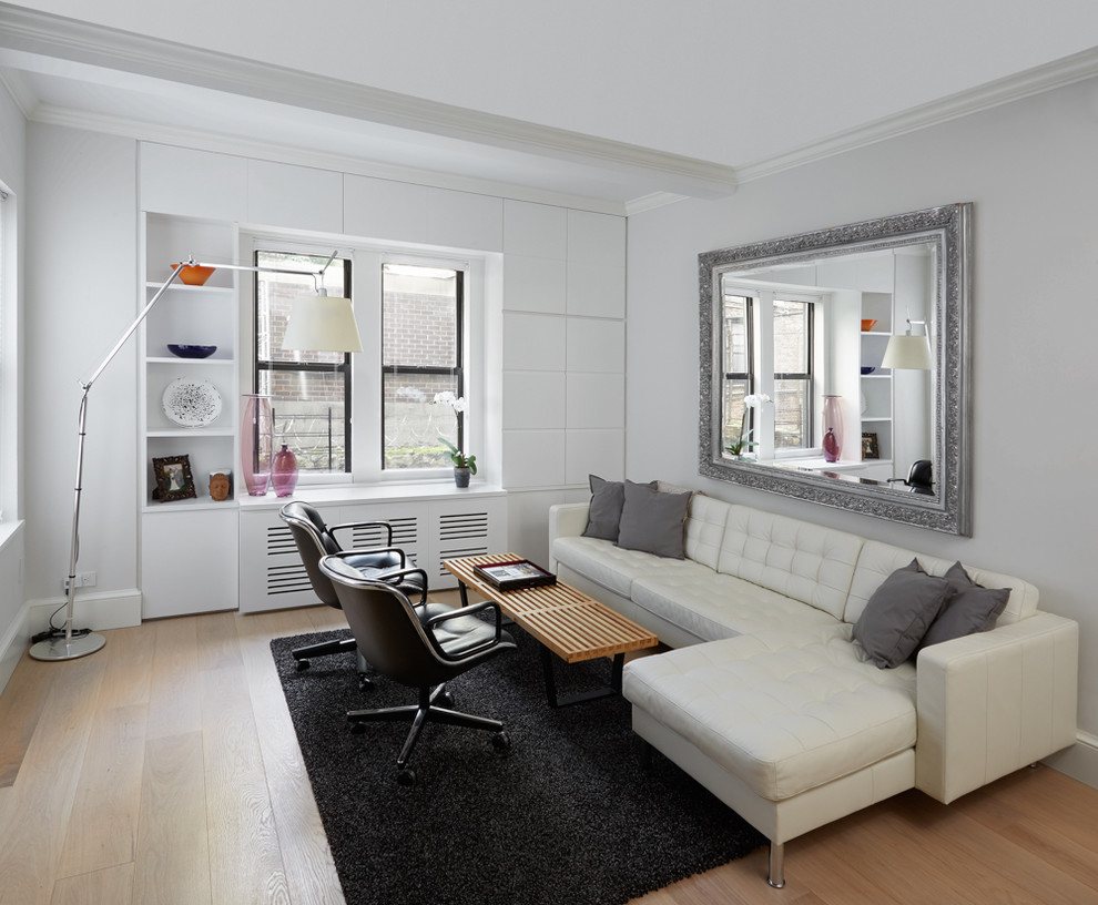 Cette photo montre une salle de séjour tendance ouverte avec un mur blanc, parquet clair et un sol beige.