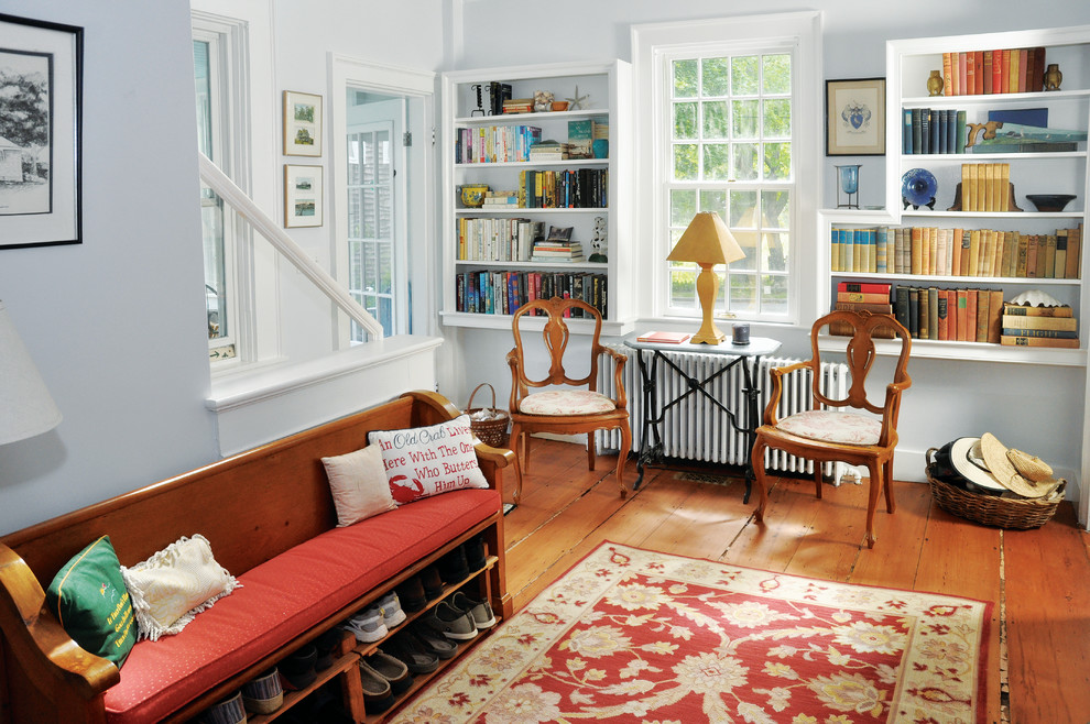 Diseño de sala de estar con biblioteca cerrada clásica con paredes azules, suelo de madera clara y suelo marrón