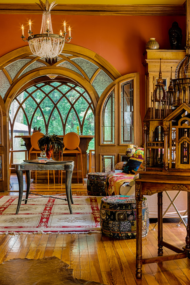 Ejemplo de sala de estar tradicional con parades naranjas y suelo de madera en tonos medios