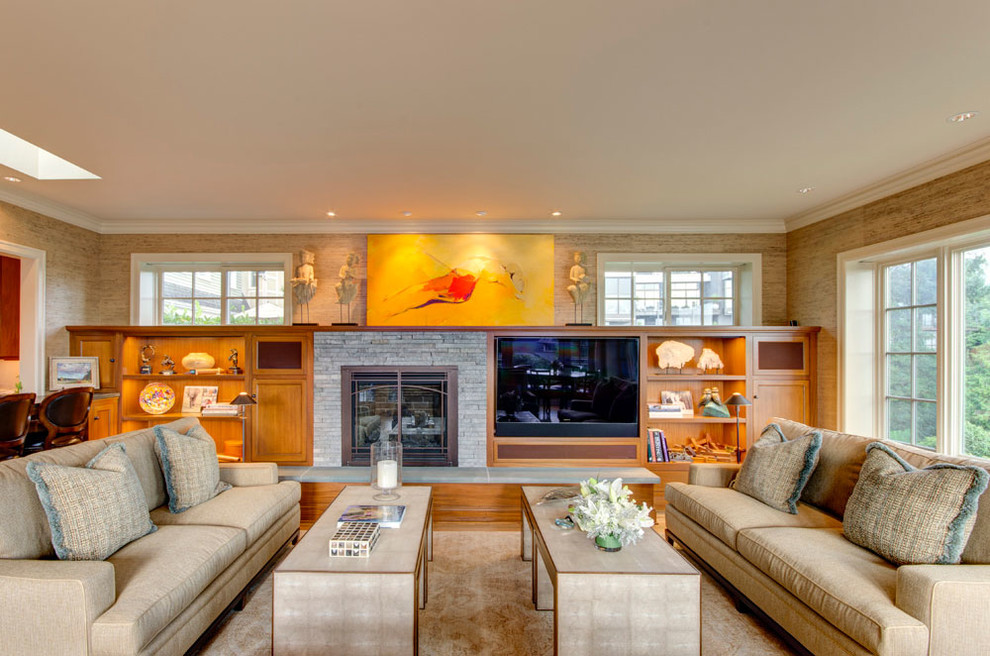 Imagen de sala de estar tradicional con paredes beige, todas las chimeneas, marco de chimenea de piedra y pared multimedia