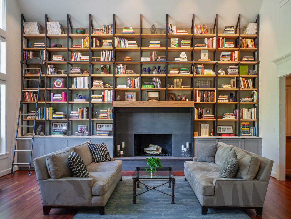 Ejemplo de sala de estar con biblioteca tradicional renovada con todas las chimeneas, marco de chimenea de metal, paredes verdes, suelo de madera en tonos medios y suelo marrón