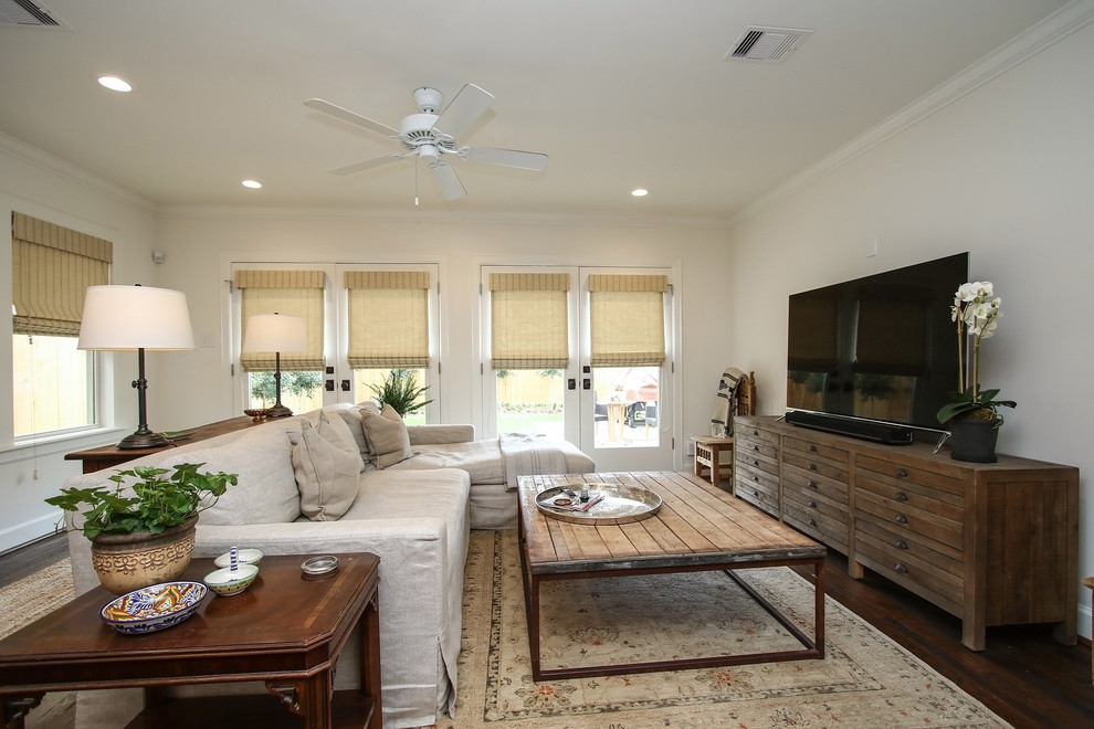 Réalisation d'une grande salle de séjour craftsman avec un mur blanc, un sol en bois brun et un téléviseur indépendant.