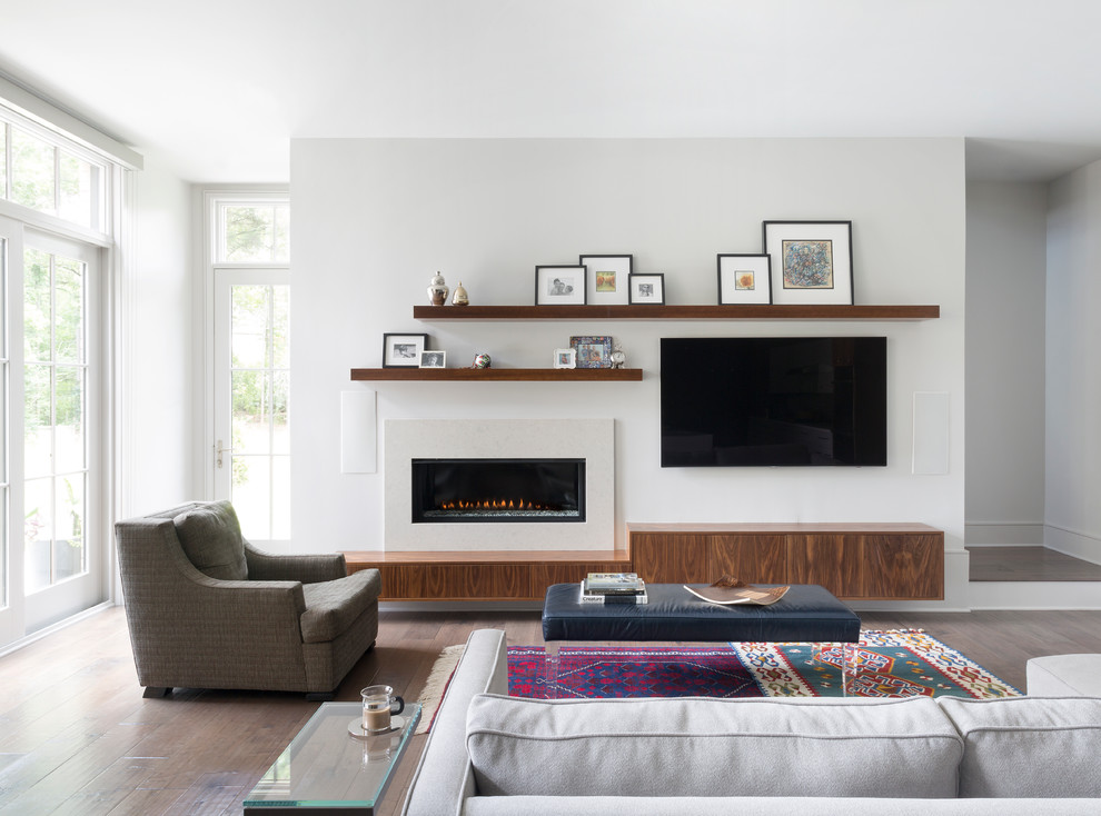 Ejemplo de sala de estar abierta, abovedada y blanca contemporánea grande con paredes blancas, suelo de madera oscura, televisor colgado en la pared, chimenea lineal, alfombra, marco de chimenea de yeso y suelo marrón