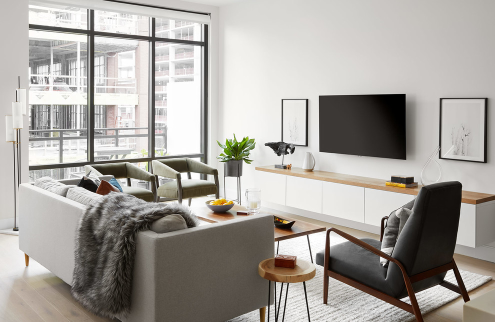 Immagine di un soggiorno contemporaneo di medie dimensioni e aperto con pareti bianche, parquet chiaro, nessun camino e TV a parete