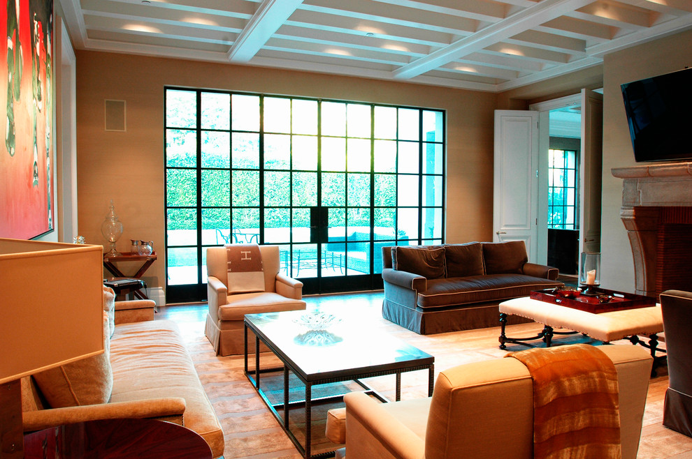 Идея дизайна: большая изолированная гостиная комната в стиле неоклассика (современная классика) с коричневыми стенами, паркетным полом среднего тона, стандартным камином, фасадом камина из камня и телевизором на стене