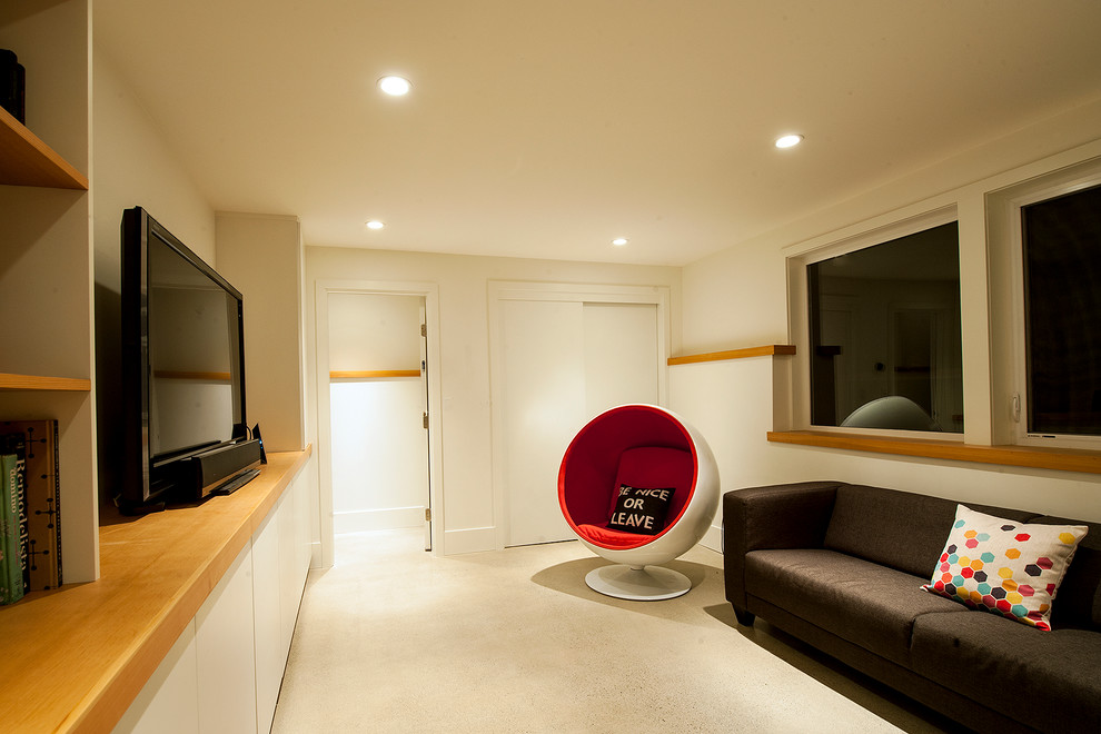 Family room - mid-sized 1960s open concept concrete floor family room idea in Vancouver with white walls and a media wall