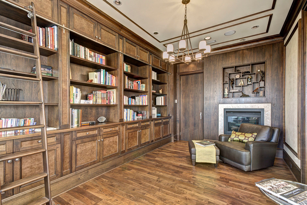 Imagen de sala de estar con biblioteca actual con suelo de madera oscura y todas las chimeneas