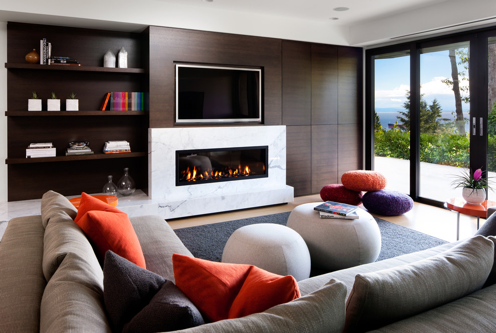 Imagen de sala de estar contemporánea con chimenea lineal, marco de chimenea de piedra y pared multimedia