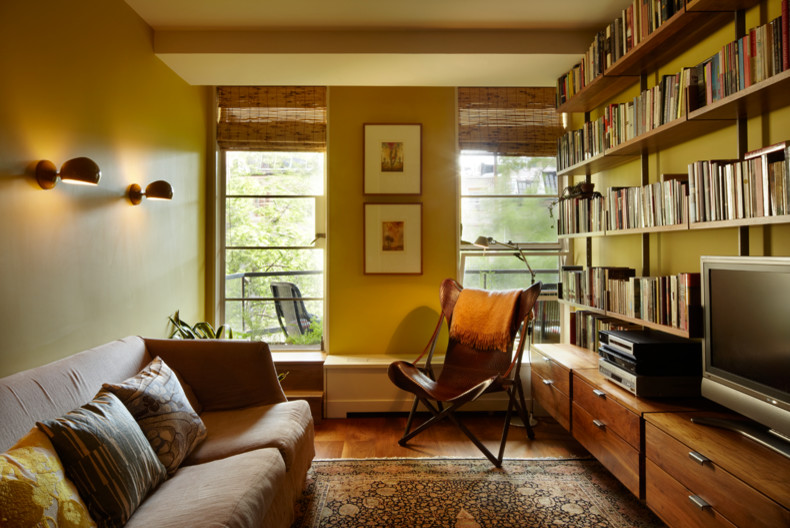 Idéer för ett mellanstort klassiskt allrum med öppen planlösning, med ett bibliotek, gula väggar, mellanmörkt trägolv, en fristående TV och brunt golv