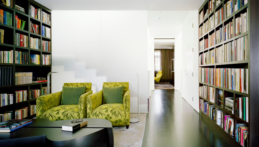 Cette image montre une salle de séjour design avec une bibliothèque ou un coin lecture et un mur blanc.