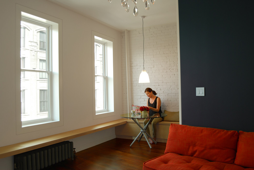 Foto di un soggiorno design con pareti nere e pavimento in legno massello medio