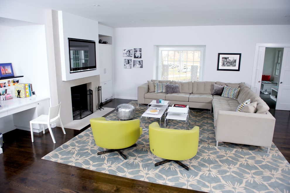 Example of a trendy dark wood floor family room design in New York with white walls, a standard fireplace and a wall-mounted tv