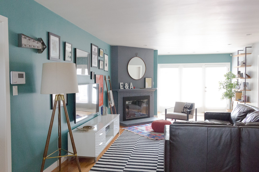Foto på ett mellanstort eklektiskt avskilt allrum, med gröna väggar, ljust trägolv, en öppen hörnspis, en spiselkrans i gips, en väggmonterad TV och beiget golv