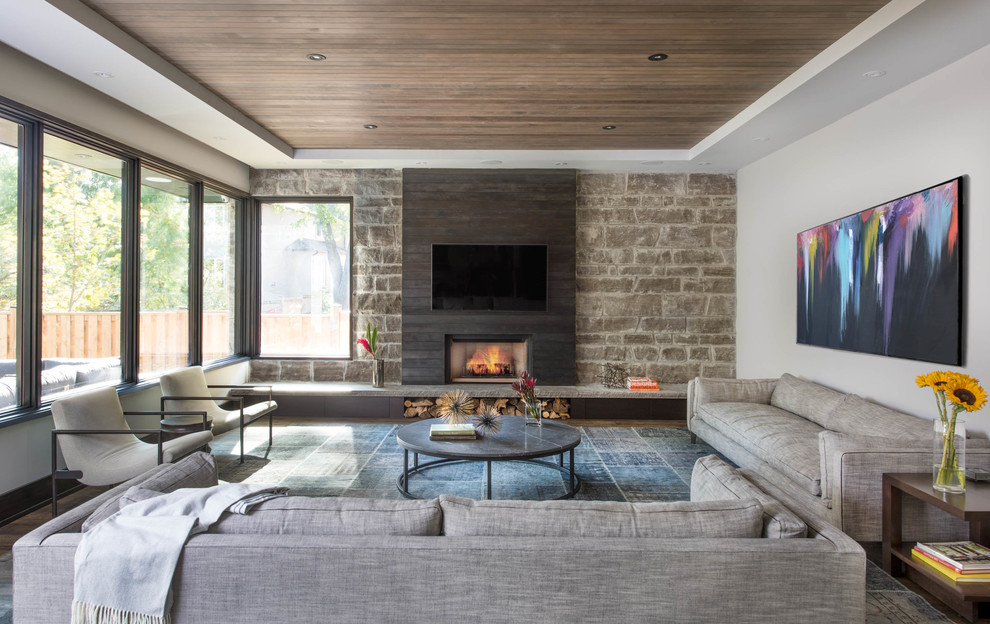 Diseño de sala de estar abierta contemporánea grande con paredes grises, suelo de madera oscura, todas las chimeneas, marco de chimenea de metal y televisor colgado en la pared