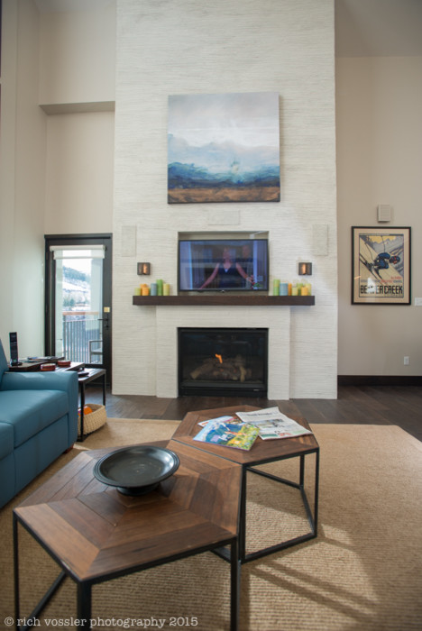 Family room - small modern loft-style dark wood floor family room idea in Denver with beige walls, a standard fireplace, a plaster fireplace and a media wall