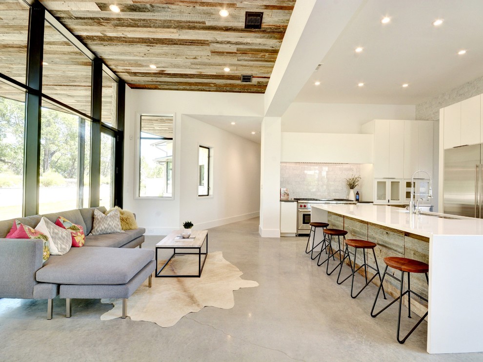 Mid-sized eclectic open concept concrete floor family room photo in Austin with white walls, no fireplace and no tv