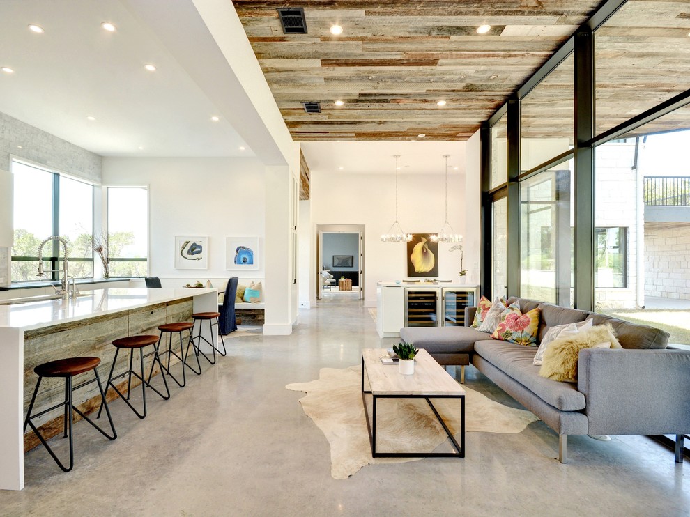 Mittelgroßes, Fernseherloses, Offenes Modernes Wohnzimmer ohne Kamin mit weißer Wandfarbe und Betonboden in Austin